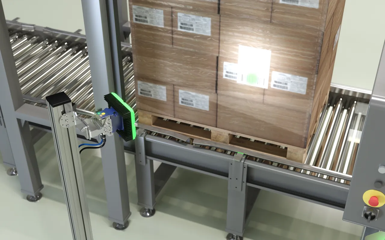 Escáner industrial Datalogic leyendo la etiqueta de un palet sobre una cinta transportadora de rodillos en el muelle de carga